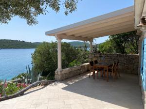 a patio with a table and chairs under a pavilion at Girica in Ugrinići
