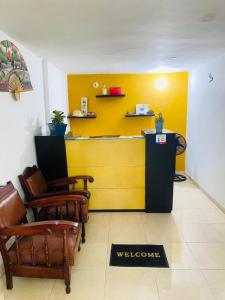 een wachtkamer met stoelen en een gele muur bij Hostal Santa Maria City in Santa Marta