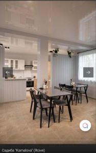 a dining room with tables and chairs and a kitchen at Садиба KAMALOVA in Yasinya