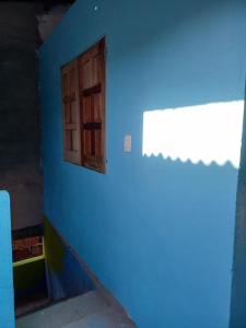 een blauwe kamer met een raam en een blauwe muur bij kitinet IMMANU'EL Moreré-Ba in Cayru