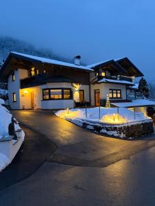 a house with lights in the snow at night at Mountain Apex in Dölsach