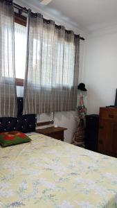 een slaapkamer met een bed en een raam met gordijnen bij Casa Shantti in Angra dos Reis