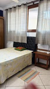 een slaapkamer met een bed en twee ramen bij Casa Shantti in Angra dos Reis