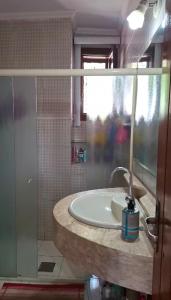 een badkamer met een wastafel en een glazen douche bij Casa Shantti in Angra dos Reis