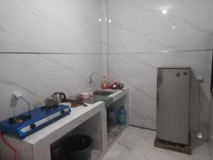 een kleine keuken met een spoelbak en een koelkast bij Femi in Keur Massar