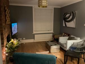 ein Wohnzimmer mit einer Couch und einem Fenster in der Unterkunft Seaside 3 bed terraced house in Hastings