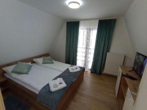 a bedroom with a bed and a window with green curtains at Vila Bosa - Stara planina in Crni Vrh +24 photos