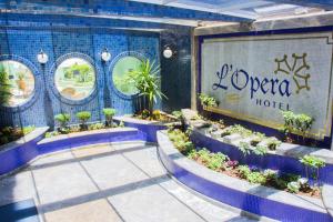 a sign for a hotel with potted plants on it at L'Opera Hotel in Sao Paulo