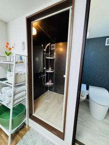 a bathroom with a shower and a toilet and a mirror at Shimokitazawa Cozy Apartment 401 in Tokyo +17 photos