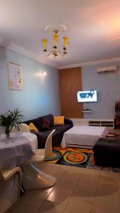 a living room with a couch and a tv at COMPLEXE L OCEANE Hotel in Kribi