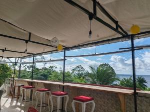 a bar with stools and a view of the ocean at COMPLEXE L OCEANE Hotel in Kribi