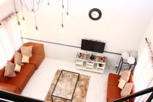 a living room with a couch and a tv at Unit 35 Pendleberry grove holidays in Bela-Bela