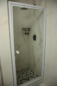 a shower with a glass door in a bathroom at Unit 35 Pendleberry grove holidays in Bela-Bela +3 photos