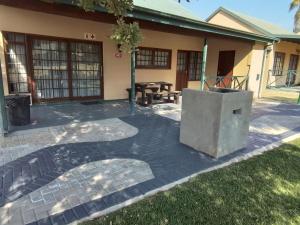 a patio with a grill in front of a house at Unit 35 Pendleberry grove holidays in Bela-Bela