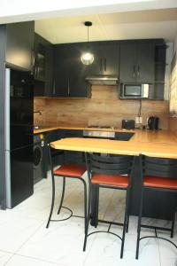 a kitchen with a wooden table and two bar stools at Unit 35 Pendleberry grove holidays in Bela-Bela