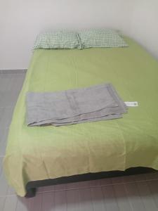 a green bed with a shirt on top of it at Casa alexander in Acapulco