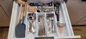 eine weiße Schublade voller silberner Utensilien in der Unterkunft Gold Apartament in Olsztyn