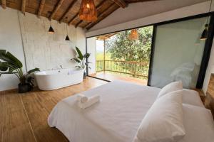a bedroom with a large bed and a tub and a sink at Tukawa in Filandia