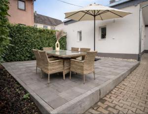 een terras met een tafel, stoelen en een parasol bij 1 BR Bungalow in Rüdesheim am Rhein