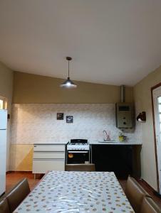 une cuisine avec une table et une cuisinière four supérieur dans l'établissement Casa en centro de Icho Cruz, à Villa Icho Cruz