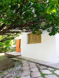 un bâtiment blanc avec une fenêtre à volet jaune dans l'établissement Casa en centro de Icho Cruz, à Villa Icho Cruz