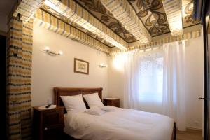 une chambre avec un lit avec des draps blancs et une fenêtre dans l'établissement La Cour du Bailli Suites & Spa, à Bergheim 78 autres photos