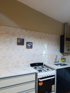 une cuisine avec une cuisinière et un évier dans l'établissement Casa en centro de Icho Cruz, à Villa Icho Cruz