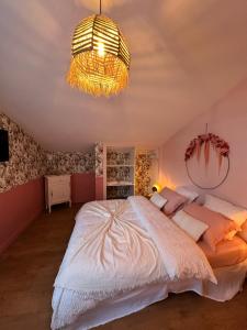 a bedroom with a large bed and a chandelier at L'écrin du sancy in La Bourboule