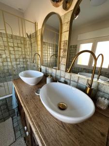 a bathroom with two sinks and two mirrors at L'écrin du sancy in La Bourboule +25 photos