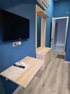 a living room with a tv and a wooden table at Favourite in Sighnaghi