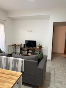 un soggiorno con un divano e una TV di Catedral Plaza Malvinas a La Plata