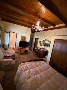 een slaapkamer met een bed en een kroonluchter bij La Arboleda - Casa de Campo in Marcos Paz