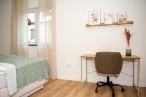 a bedroom with a desk and a bed and a chair at 1 BR Bungalow - 1 Schlafzimmer - große Terrasse - Café - Sekt - an den Weinbergen in Rüdesheim am Rhein +10 photos