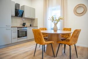 een keuken met een tafel met stoelen en een vaas met bloemen bij 1 BR Bungalow in Rüdesheim am Rhein