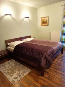 a bed in a bedroom with two lights on the wall at Apartament WENGE w centrum Ustronia in Ustroń