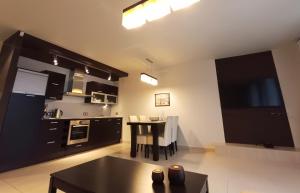 a kitchen with a table and a dining room at Apartament WENGE w centrum Ustronia in Ustroń