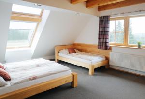 una camera da letto con due letti e due finestre di Apartmány Modrava a Modrava