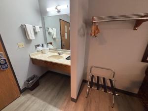 a bathroom with a sink and a mirror and a stool at Covered Bridge Inn in Winterset
