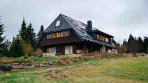 a large wooden house on top of a hill at Apartmány Modrava in Modrava