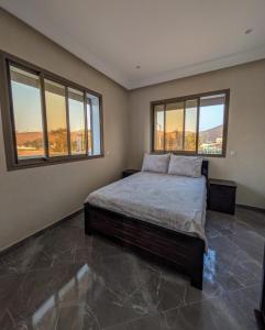 una camera da letto con un letto grande e finestre di Appartement Calme Sidi Ifni a Sidi Ifni