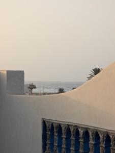 un edificio bianco con finestre blu e l'oceano di Appartement Calme Sidi Ifni a Sidi Ifni Altre 7 foto