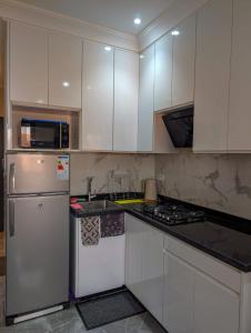 una cucina con mobili bianchi e un frigorifero bianco di Appartement Calme Sidi Ifni a Sidi Ifni