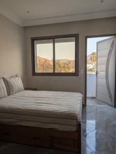 una camera da letto con un letto grande con due finestre di Appartement Calme Sidi Ifni a Sidi Ifni