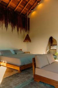 een slaapkamer met 2 bedden en een bank bij Pousada Casa Buriti - Atins in Atins