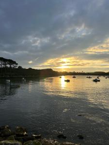 a group of boats on a river at sunset at PORTSALL - La Demeure de Tréompan in Ploudalmézeau