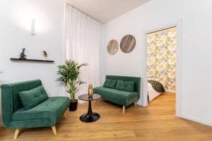 ein Wohnzimmer mit 2 grünen Stühlen und einem Tisch in der Unterkunft Frascati's Most Exclusive Stay Central Square in Frascati