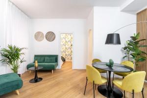 ein Wohnzimmer mit einem grünen Sofa, einem Tisch und Stühlen in der Unterkunft Frascati's Most Exclusive Stay Central Square in Frascati