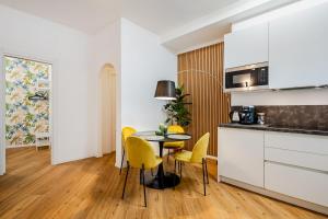 eine Küche mit einem Tisch und gelben Stühlen in einem Zimmer in der Unterkunft Frascati's Most Exclusive Stay Central Square in Frascati + 19 Fotos