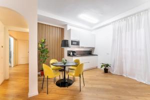ein Esszimmer mit einem Tisch und gelben Stühlen in der Unterkunft Frascati's Most Exclusive Stay Central Square in Frascati