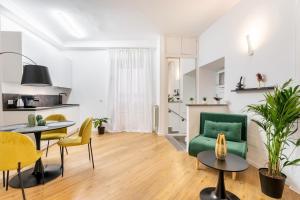 een woonkamer met een groene stoel en een tafel bij Frascati's Most Exclusive Stay Central Square in Frascati